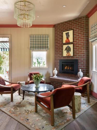 a living room with a fireplace and a table and chairs at Le Petit Pali St Helena in St. Helena