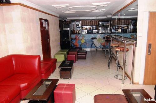 a waiting room with red couches and a bar at Prince Of Anthony 1960 Hotel-apartment in Lagos