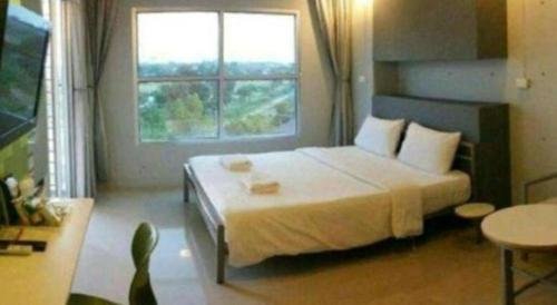 a bedroom with a large bed and a window at A+ Hotel in Ubon Ratchathani