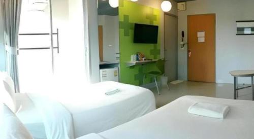 a hotel room with two beds and a television at A+ Hotel in Ubon Ratchathani