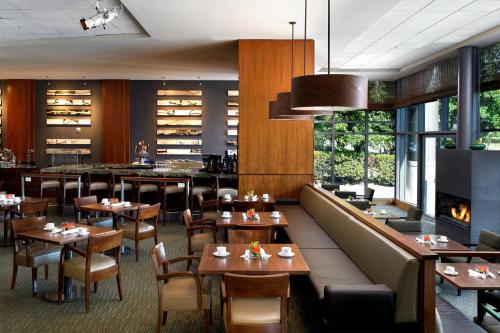 a restaurant with wooden tables and chairs and a fireplace at The Westin Bellevue in Bellevue