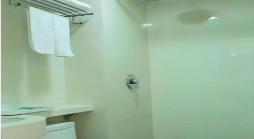 a bathroom with a toilet and a sink and a door at Kunlun Leju Business Hotel Kaifeng Gulou in Kaifeng