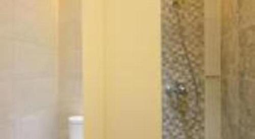 a bathroom with a shower curtain and a toilet at Griya Jogja Hotel in Yogyakarta