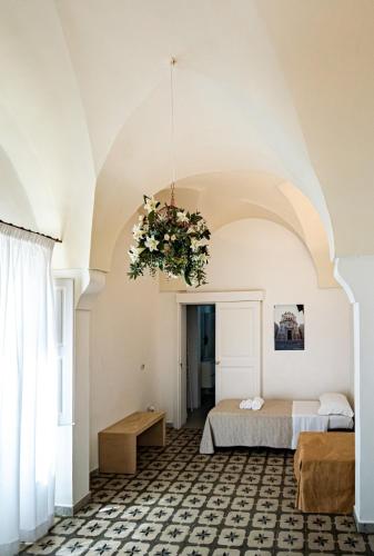 a bedroom with two beds and a chandelier at Tenuta San Nicola in Novoli