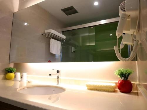 a bathroom with a sink and a large mirror at GreenTree Inn Xuancheng Jingxian Wannan First Street Express Hotel in Xuanzhou