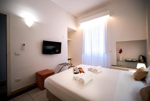 a hotel room with two beds and a tv on the wall at Tenuta San Nicola in Novoli