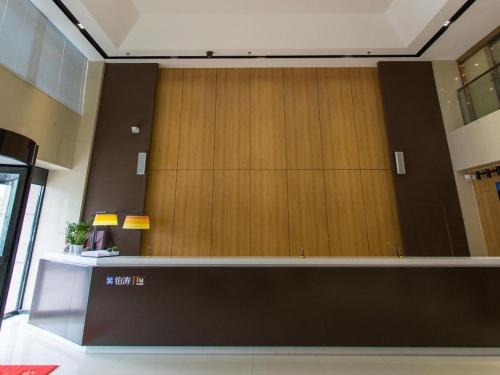a lobby with a large wall of wooden panels at IU Hotel·Weifang High-tech Zone Huijin Tower in Weifang