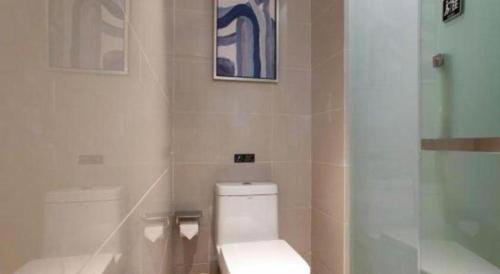 a bathroom with a toilet and a glass shower at Echarm Hotel Jingjiang Bus Passenger Station Fanggu Street in Jingjiang