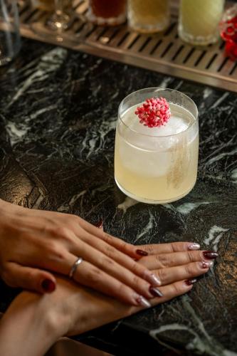 a woman with her hands on a table next to a candle at Veranda Resort Phuket, Autograph Collection in Panwa Beach