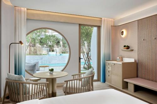 a bedroom with a bed and a table and chairs at Veranda Resort Phuket, Autograph Collection in Panwa Beach