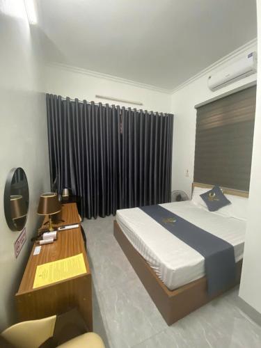 Un dormitorio con una cama y un escritorio y una ventana. en Hạ Long Xanh, en Hanói