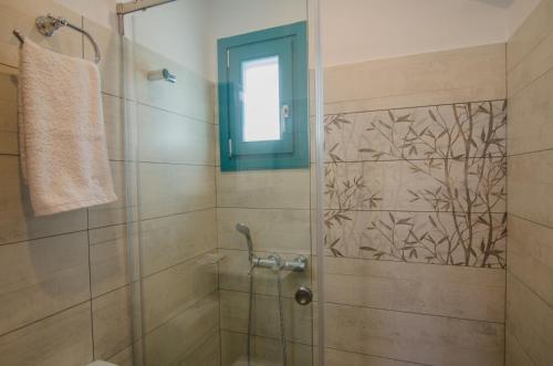 a bathroom with a shower with a glass door at Ios Sea View in Ios Chora