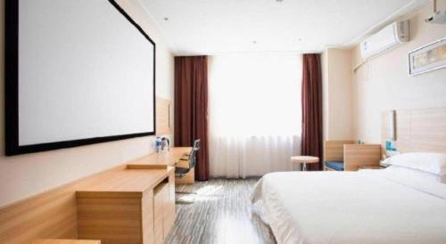 a hotel room with a bed and a projection screen at City Comfort Inn Yichang Dongshan Three Gorges University Shuiyuecheng in Yichang