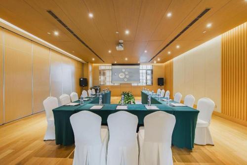 a conference room with a long table and white chairs at Deefly Yinrun Town Hotel in Deqing