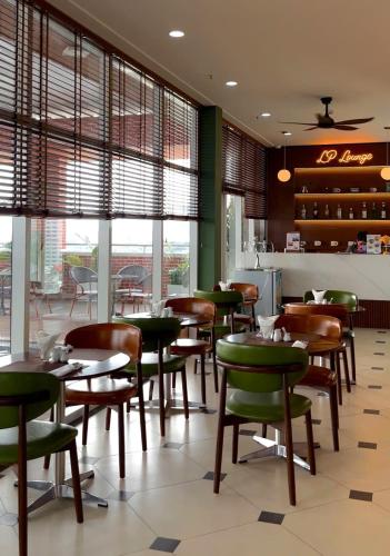 a restaurant with wooden chairs and tables and windows at Record Hotel in Da Nang