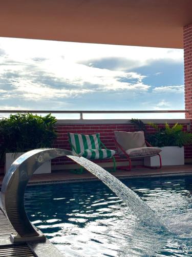 a pool with a water fountain in the middle at Record Hotel in Da Nang