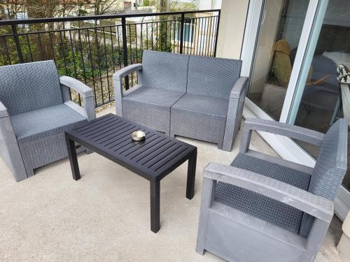 a patio with two chairs and a table and a couch at La marine D'opale in Ambleteuse
