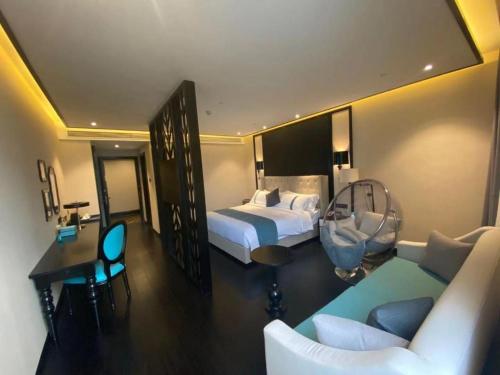 a hotel room with a bedroom with a bed and a couch at Xana Hotelle Wuxi Railway Station Zhongshan Road in Wuxi