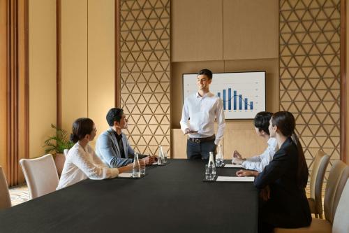a man standing in front of a group of people around a table at Sheraton Cebu Mactan Resort in Mactan