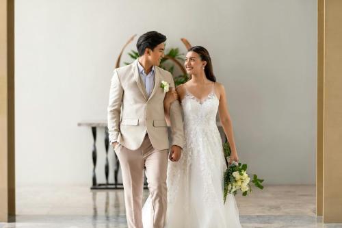a bride and groom walking down the aisle at Sheraton Cebu Mactan Resort in Mactan