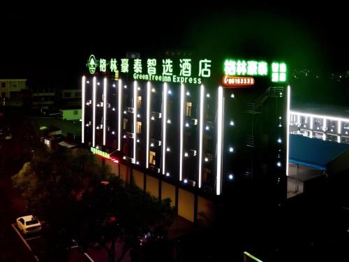 a large building with a sign on it at night at GreenTree Inn Linhai Jiangnan Avenue Express in Linhai