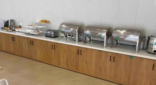 a kitchen counter with four trays on top of it at GreenTree Inn Dalian Jinzhou District Railway Station Ansheng Plaza in Dalian
