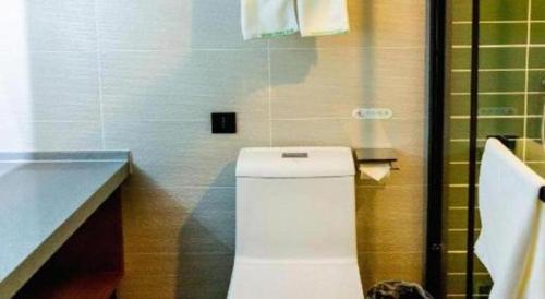 a bathroom with a white toilet and a counter at GreenTree Inn Express Datong High-Speed Railway Station Wanda Plaza Fangte in Datong
