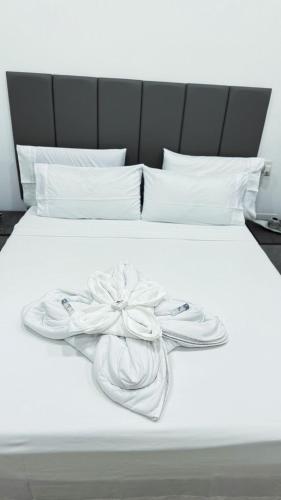 a white bed with a bow on top of it at Le bougainvillea 1 in Corbetta
