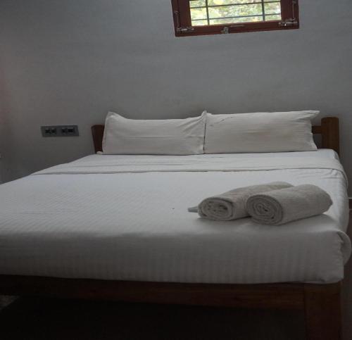 a bed with two rolled towels on it at Vasantharaja Villa Ariyankuppam in Pūrnānkuppam