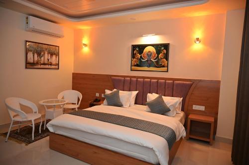 a bedroom with a bed and a table and chairs at Hotel Om Elite Stay in Jaipur