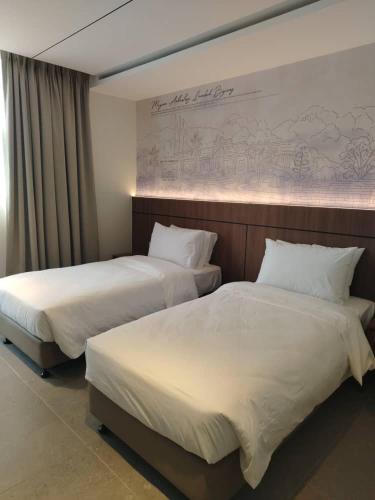two beds in a hotel room with white sheets at The Jerai Hotel Sungai Petani in Sungai Petani