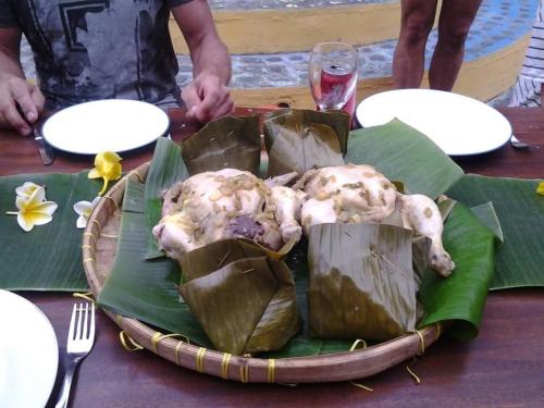 two chickens sitting on a plate on a table at Kubu Pilatus – Family House Lombok in Tjakranegara