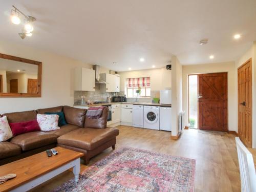 a living room with a couch and a table at Old Hall Barn 1 in Church Stretton