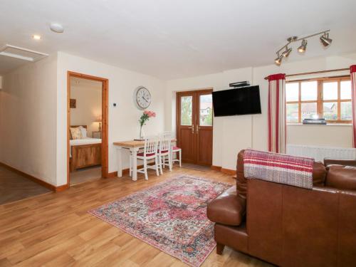 a living room with a couch and a table at Old Hall Barn 1 in Church Stretton