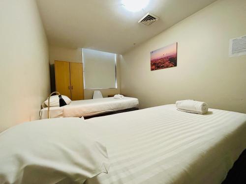 a room with two beds in a room with at Siesta Sydney in Sydney
