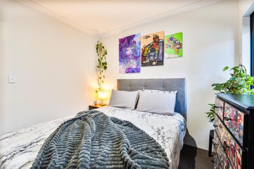 a bedroom with a bed and paintings on the wall at Luxe Cosy Room in Beechboro in Perth