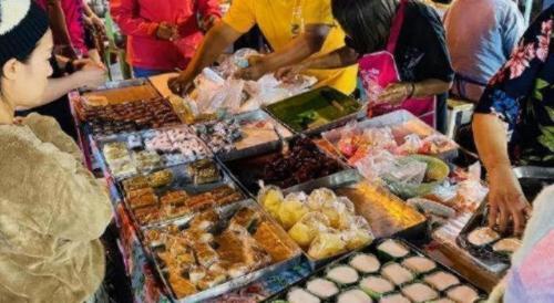 a group of people standing around a buffet of food at Niwtara Place Lom Sak Hotel in Phetchabun