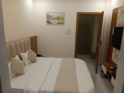 a bedroom with a large white bed with pillows at Vaikuntha Stays Hotel in Indore