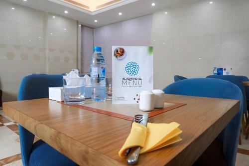 a wooden table with a napkin and a bottle of water at ALAZMI HOTEL in Dubai