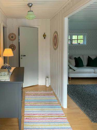 a living room with a couch and a rug at Cosy Forest Cabin Near Bollnäs in Bollnäs