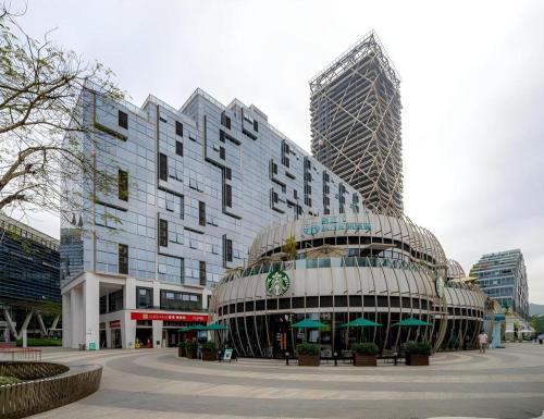 a large building in a city with tall buildings at F-TOWN Fangtang Hotel (Shenzhen Longgang Tian'an Digital City Huanggekeng Subway Station) in Shenzhen