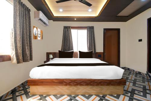 a bedroom with a large white bed and a window at Super Collection O Sea Beach Puri Formerly Hotel BB Palace in Puri