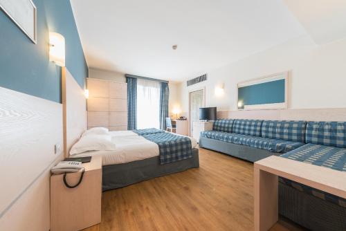 A bed or beds in a room at Caravel Bike Hotel
