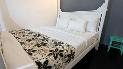 a bed with a black and white blanket and pillows at Amurasan beach studio in Tangalle