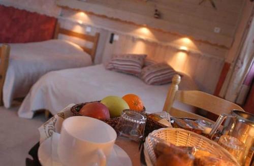 una mesa con un bol de fruta y una cama en La Boule de Neige, en Samoëns