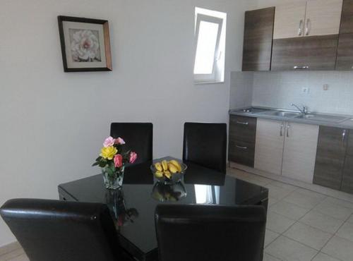 a kitchen with a table with chairs and flowers on it at Villa Apartments Kumbor President in Kumbor