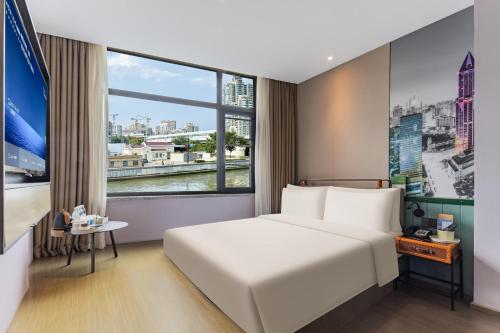 a hotel room with a large bed and a window at Atour Light Hotel Shanghai Jing'an Natural History Museum, Suzhou River Bank in Shanghai