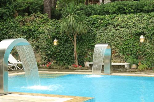 two water fountains in a swimming pool at Luxury Relais Villa Magdalena in Ischia