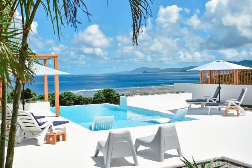 a villa with a pool and a view of the ocean at Ocean View Ishigaki Kaze and Nami in Ishigaki Island