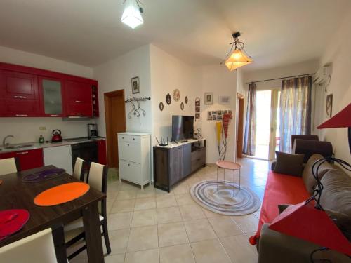 a kitchen and a living room with a couch and a table at Little Pearl in Orikum